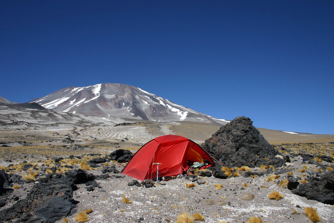 Rött tält uppslaget med berg i bakgrunden